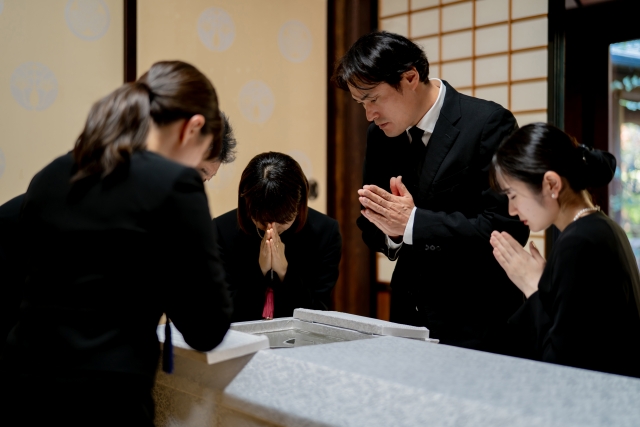 柩の中の故人を遺族たちが取り囲み、冥福を祈りお別れをしている様子。